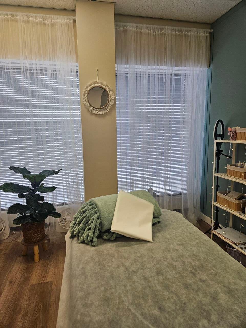 Treatment table with green blanket and pillow in Oh, Honey studio